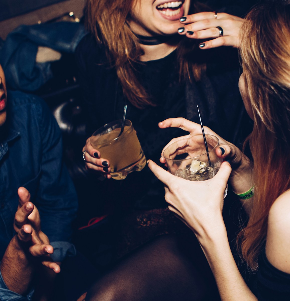 Photo by Michael Discenza two women talking while holding drinking glasses