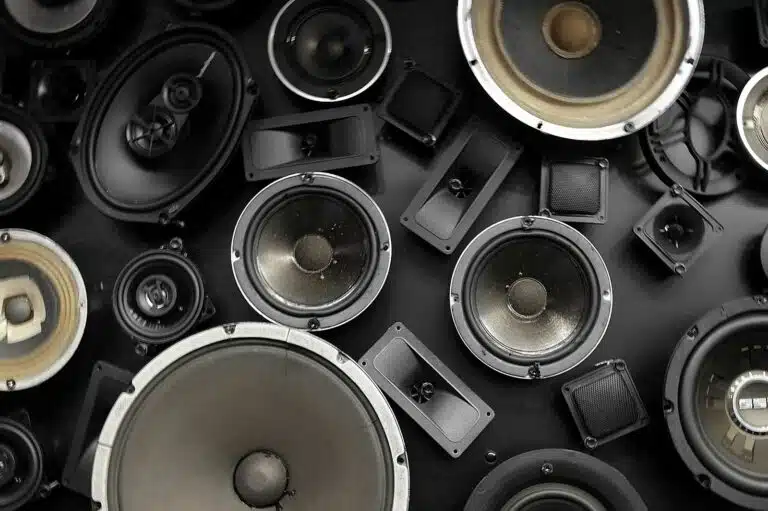 a bunch of speakers that are sitting on a table after being destroyed by excessive speaker boundary interference response (SBIR) and room modes.