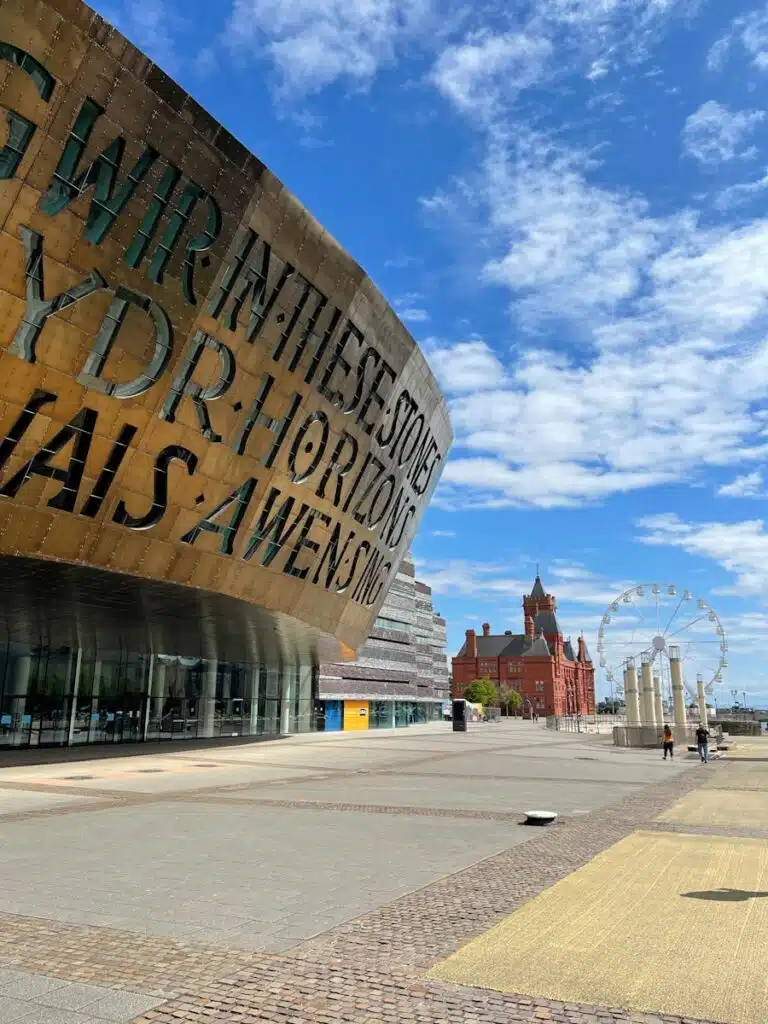 a large building with a clock on the side of it in Cardiff. Noise assessment in Wales.