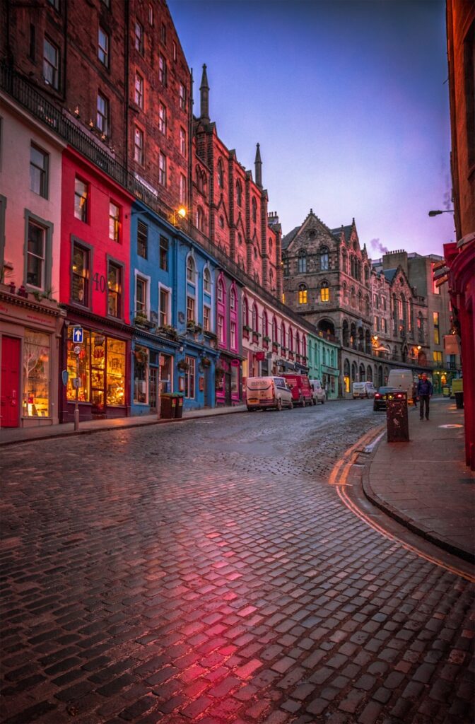 people walking on sidewalk near red concrete building during daytime noise consultants in Scotland.