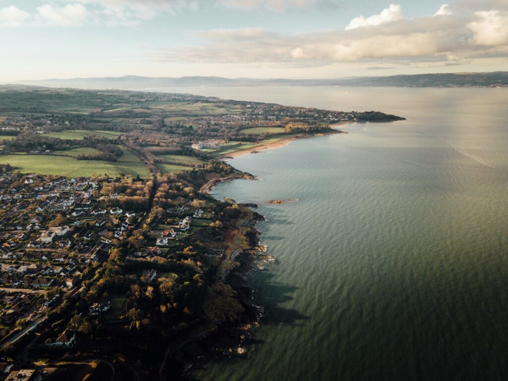 aerial view of green trees and body of water during daytime Northern Ireland acoustic consultants.