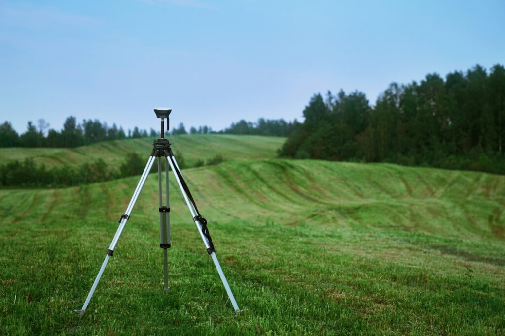 black and white tripod on green grass field during daytime with environmental noise solutions for planning consent.