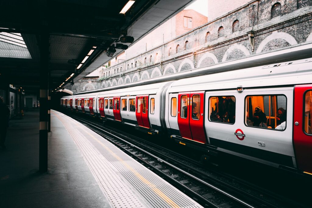 white and red train beside building at daytime railway noise assessment survey
