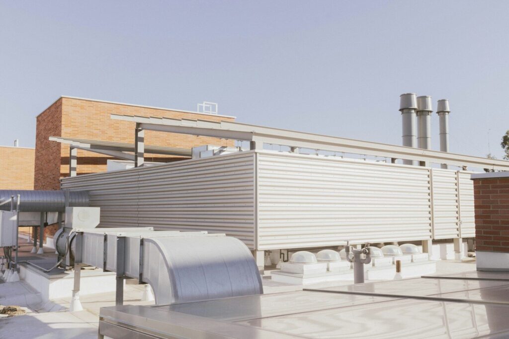 a building with a lot of pipes on the roof and acoustic mitigation based on Noise impact assessment report structure for UK planning applications